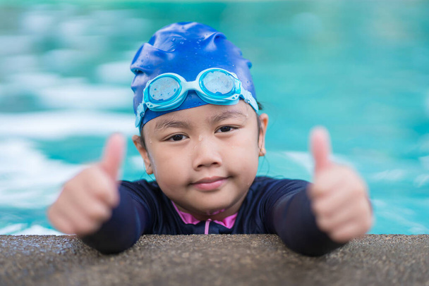 happy children Smiling cute little girl in sunglasses in swimming pool. - Photo, Image
