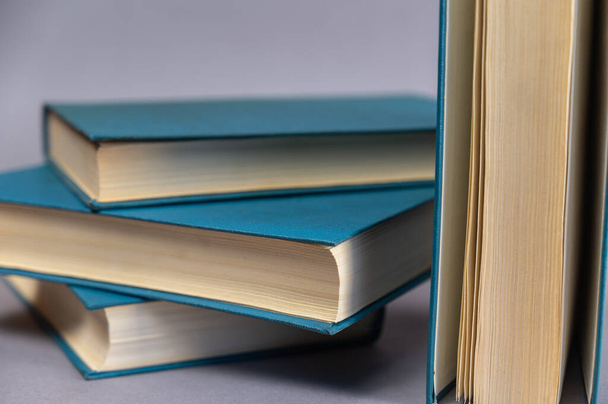 Een paar boeken in blauwe omslag tegen een grijze achtergrond. Een groep hardcover boeken. Close-up. - Foto, afbeelding