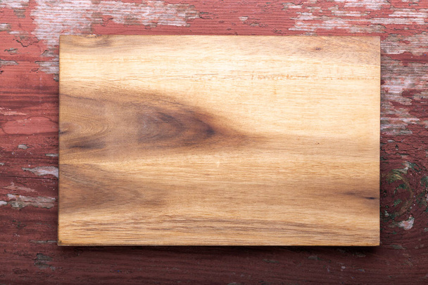 Empty cutting board on a wooden background. Top view. Space for text. - Φωτογραφία, εικόνα
