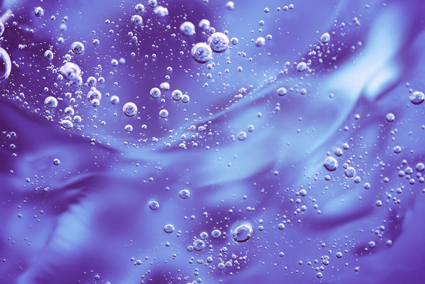 Close up macro Aloe vera gel cosmetic texture violet background with bubbles. - Photo, image