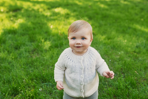 Lachende kleine jongen op gras in het park. Dag van de kinderbescherming. Wereldkinderdag. - Foto, afbeelding
