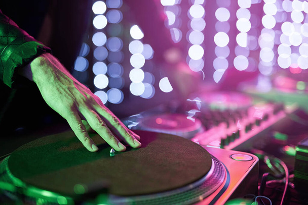 Laying down some beats. Closeup shot of a DJ mixing music on a turntable. - Zdjęcie, obraz