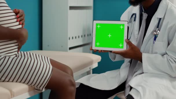 Medical specialist showing horizontal greenscreen on tablet - Filmati, video