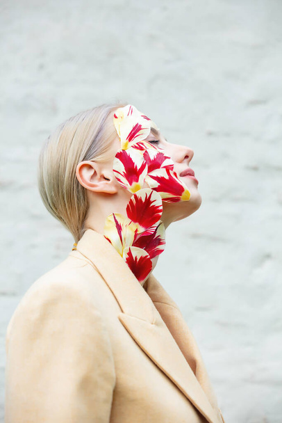 Красива жінка з тюльпанами пелюстки на обличчі на білому тлі
 - Фото, зображення