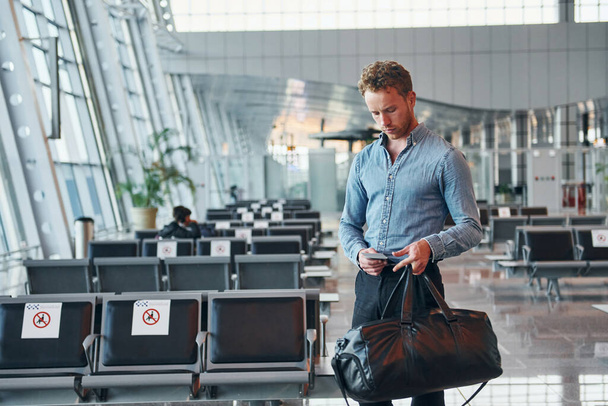 Young man in formal wear is in modern airport. Conception of vacation. - Foto, Imagen