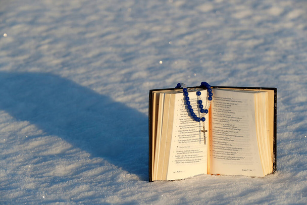 雪の上で一般的な祈りとロザリオの本。ノルウェー.  - 写真・画像