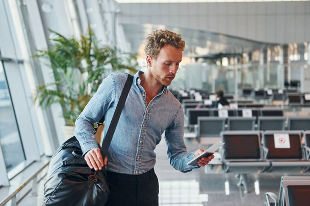 Young man in formal wear is in modern airport. Conception of vacation. - Foto, imagen