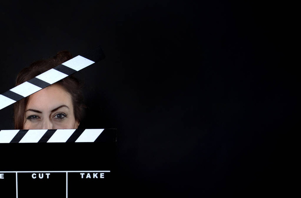 Πορτραίτο μιας όμορφης νεαρής γυναίκας με γυψοσανίδες, που κρατά γυψοσανίδες, παραγωγή ταινιών και κινηματογραφική ιδέα  - Φωτογραφία, εικόνα