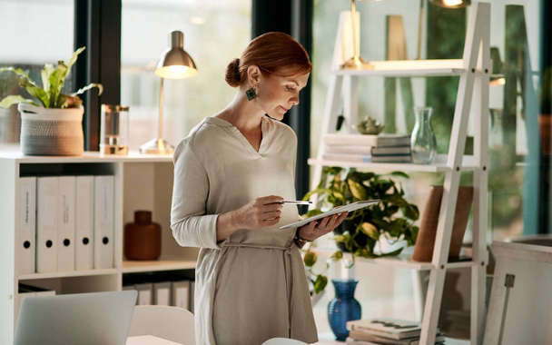 The smart way to stay organised. Shot of a young businesswoman using a digital tablet in a modern office. - Foto, Imagem
