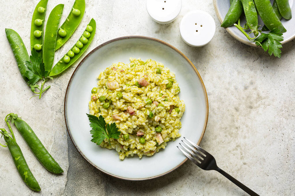Italian, Venetian rice and spring green pea. Risi e bisi.  Spring dish made with Vialone nano rice, green peas, parsley and bacon. Ingredients. Horizontal image, copy space. - Fotó, kép
