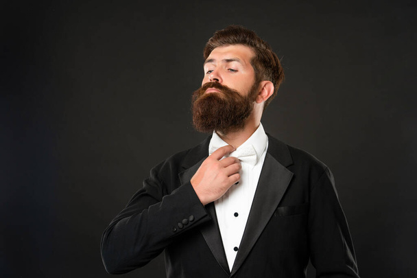 brutal gentleman in tuxedo on black background, suit - Фото, изображение