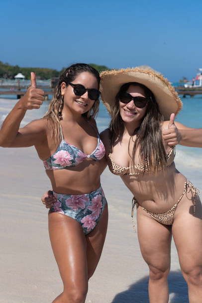Портрет двух молодых латиноамериканцев, веселящихся на пляже - Фото, изображение