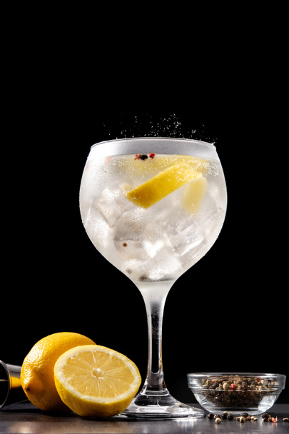 Gin tonic drink into a glass on black background - Фото, изображение