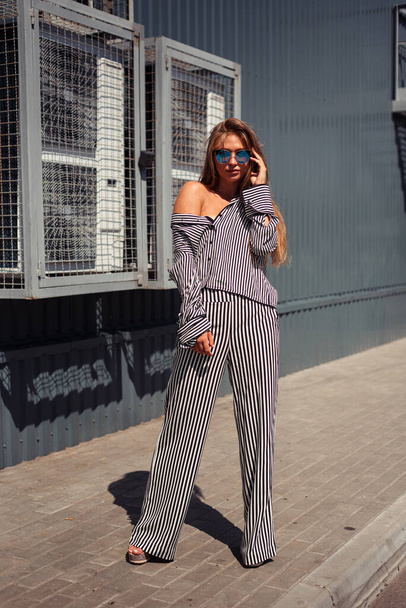 City Style. Designer clothing. Girl in pajamas in the city. The shirt is off the shoulder. - Fotoğraf, Görsel