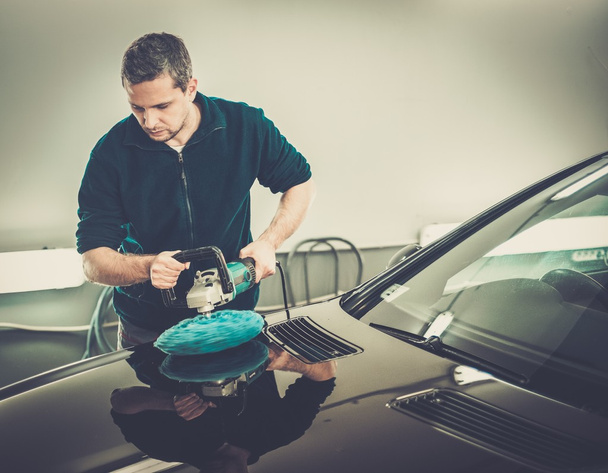 Чоловік на автомийці полірує машину з полірувальною машиною
  - Фото, зображення