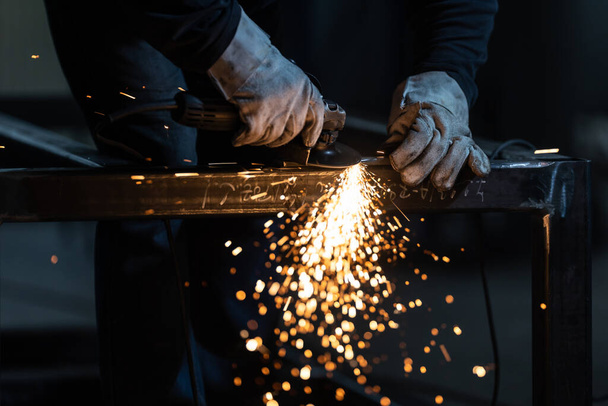 Man working on iron with grinder. Man at work. Sparkles and fire from grinder cutting. Grinder. Worker. - Foto, imagen