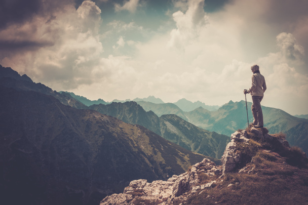 Nainen patikoija vuoren huipulla
  - Valokuva, kuva