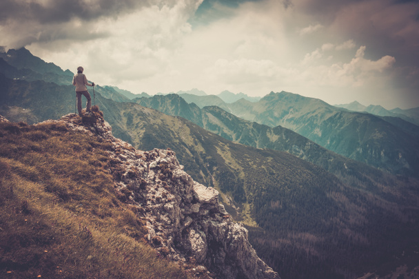 Nainen patikoija vuoren huipulla
  - Valokuva, kuva