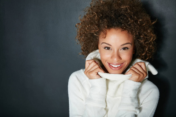 Gemütlicher Stil für die kühleren Jahreszeiten. Studioporträt einer attraktiven jungen Frau in Winterkleidung vor dunklem Hintergrund. - Foto, Bild