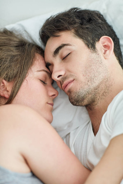 Sharing the moments that matter. Shot of a relaxed young couple sleeping in bed together at home. - Fotoğraf, Görsel