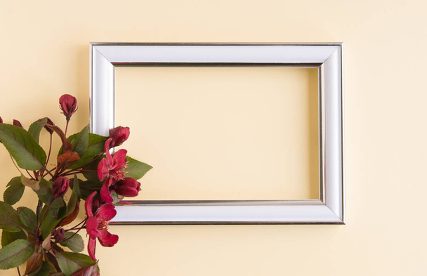 Beautiful flower arrangement. A branch of red flowers, an empty photo frame for text on a light pastel background. Wedding. birthday. Valentine's Day, Mother's Day. Top view, copy space - Zdjęcie, obraz