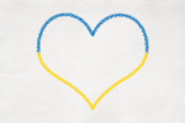 Heart shape crayon drawing on white textured paper in Ukrainian Flag colors: blue and yellow. - Zdjęcie, obraz