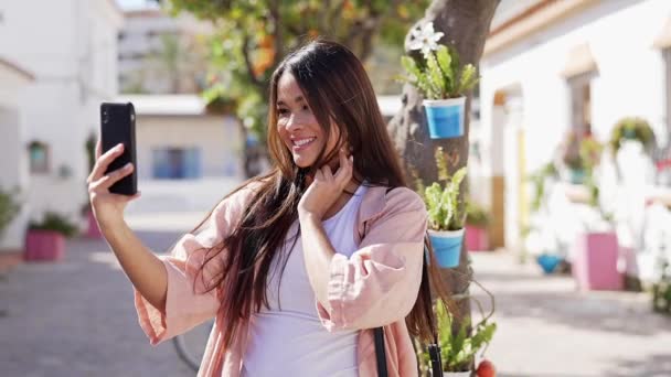 Mujer hispana alegre usando smartphone en la calle - Imágenes, Vídeo