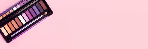 Színes szemhéjpúder paletta rózsaszín háttér másolási hely banner. Színes szemhéjpúder paletta ecsettel. Széles panorámás fejléc - Fotó, kép