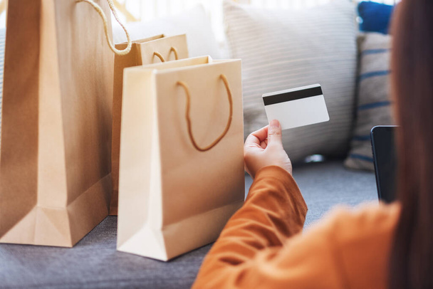 Imagen de cerca de una mujer joven usando el teléfono móvil y la tarjeta de crédito para ir de compras en línea - Foto, imagen