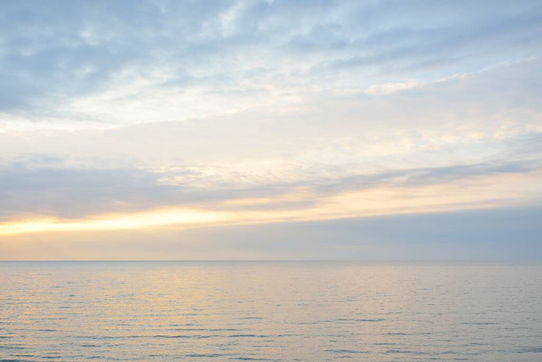 Panoramaaufnahme von der Ostseeküste bei Sonnenuntergang. Dramatische Wolkenlandschaft, glühende Wolken, goldenes Sonnenlicht nach dem Sturm. Natur, Umwelt, Klimawandel, unbeständiges Wetter - Foto, Bild