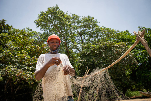 African fisherman is setting up the fishing net to go to work, person at work - Fotó, kép