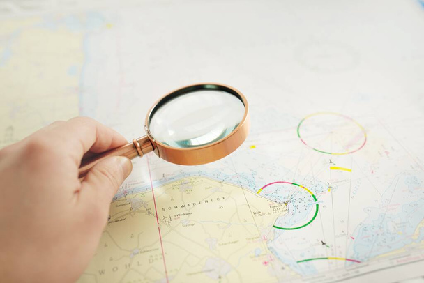 Brass magnifying glass and white nautical chart close-up. Vintage still life. Sailing, travel accessories. Planning, concept art, graphic resources, copy space - Photo, Image
