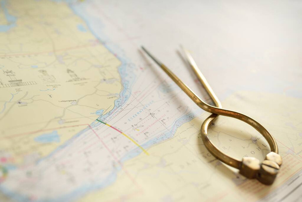 Antik W HC 6 "sárgaréz elválasztó kalipers tengerészeti navigációs chart eszköz és fehér térkép közelkép. Vintage csendélet. Vitorlázás, utazási kellékek. Tervezés, koncept művészet, grafikai erőforrások, másolás - Fotó, kép