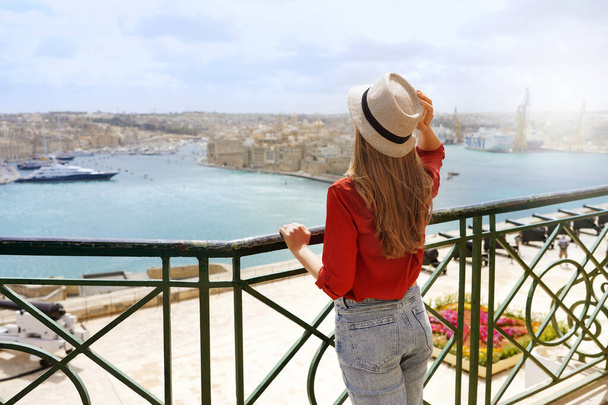 Τουρισμός στη Μάλτα. Επιστροφή άποψη του όμορφου κοριτσιού απολαμβάνοντας θέα των τριών πόλεων από Upper Barrakka Gardens, Valletta, Μάλτα. - Φωτογραφία, εικόνα