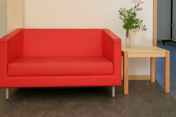 赤いソファと小さな木製のテーブル - 写真・画像