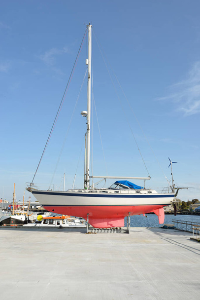45 ft cruising sailboat standing on land in a yacht marina. Transportation, nautical vessel, repair and service, sailing, sport, recreation. tourism, leisure activity concepts - Foto, immagini
