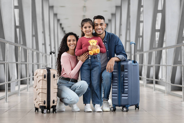 Viaje de vacaciones. Retrato de la feliz familia árabe joven posando en la terminal del aeropuerto - Foto, imagen