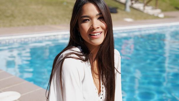 Cheerful ethnic woman near swimming pool - Photo, Image