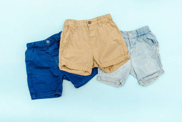 Літні діти синій одяг та аксесуари з джинсовими шортами. Сучасний модний дитячий одяг. Набір дитячого одягу для весни або літа. Плоский ліжко, вид зверху, над головою, макет
 - Фото, зображення