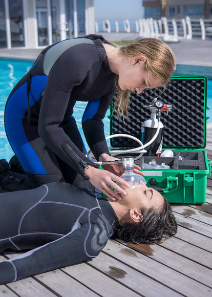 Scuba Diving rescue course skills providing oxygen to injured or unconscious diver - 写真・画像