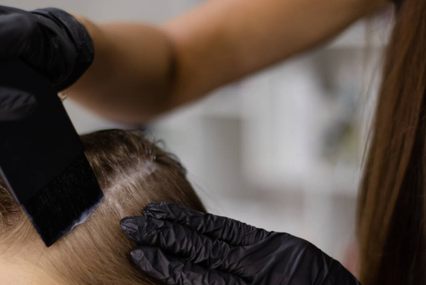 applying cream or ointment or paint or medicine on the head to the hair. head hair treatment, hair care. beauty salon, cosmetology. - Fotoğraf, Görsel