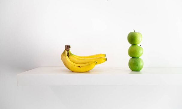 Πράσινα μήλα και μπανάνες σε λευκό φόντο γκρο πλαν. - Φωτογραφία, εικόνα