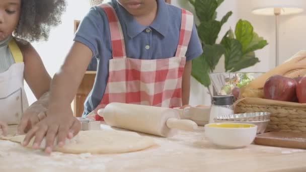 African American family with son and daughter cut flour is shape for cooking cookies with father together in the kitchen at home, parent and little child activity preparing food with fun, lifestyle concept. - Filmmaterial, Video