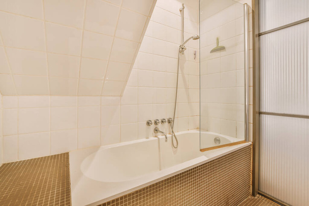 Spacious beige bathroom with shower cabin in bathtub - Photo, Image