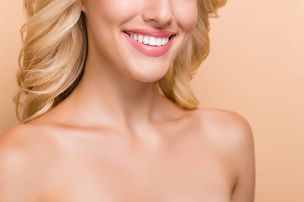 Cropped view portrait of attractive cheerful wavy-haired woman perfect implant teeth isolated over beige pastel color background - Zdjęcie, obraz