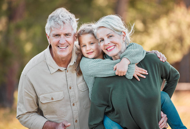 We love coming out with our grandchild. Shot of a senior couple spending time outdoors with their granddaughter. - Photo, image