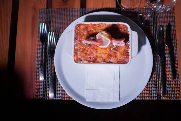 Zeevruchten lasagne in een glanzende pot op tafel - Foto, afbeelding