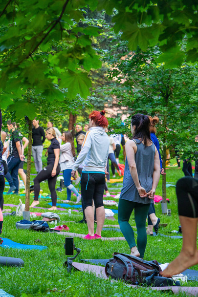 Lviv, Ukraine - July 2, 2021: lot of people at city park do yoga close up - Zdjęcie, obraz