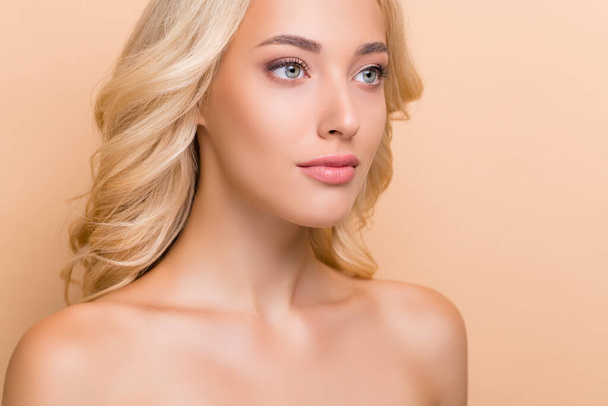 Cropped view portrait of attractive perfect wavy-haired girl flawless makeover isolated over beige pastel color background - Fotó, kép