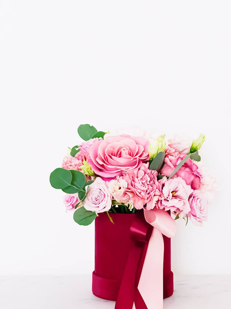 Schöner Strauß blühender Blumen in rotem Blumenkasten auf weißem Hintergrund, Urlaubsgeschenk, luxuriöses Blumendesign-Konzept - Foto, Bild